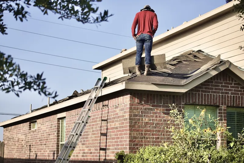Professional roofer working on a residential roof in Plateau